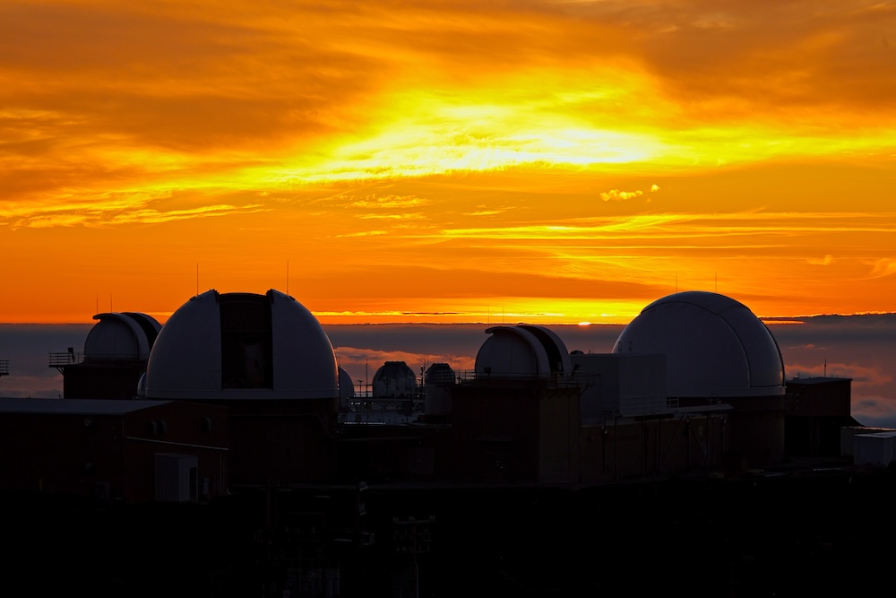 The sun sets above the clouds at the summit of the Haleakala volcano on Maui